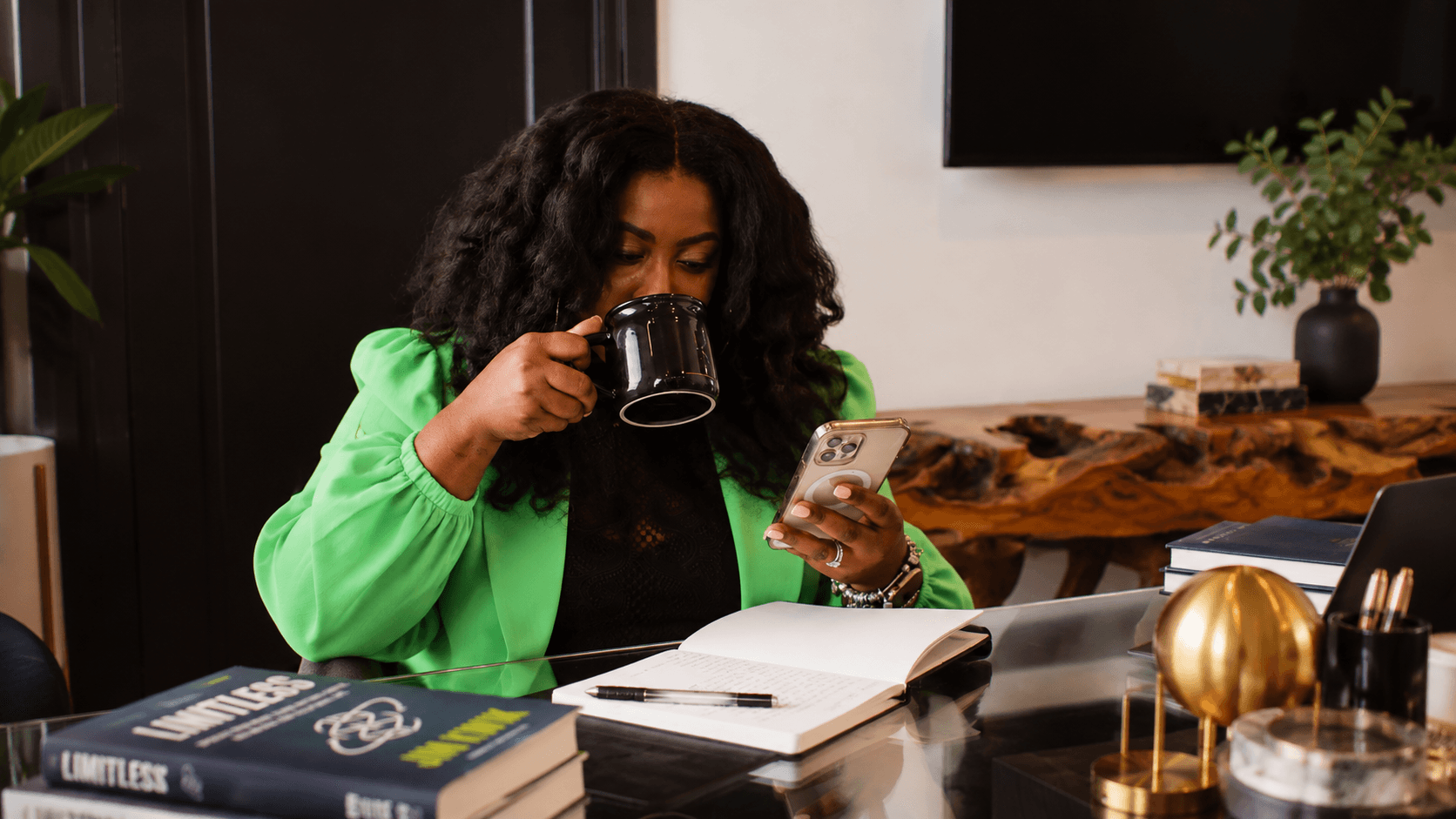 A business owner reviewing her phone at a desk