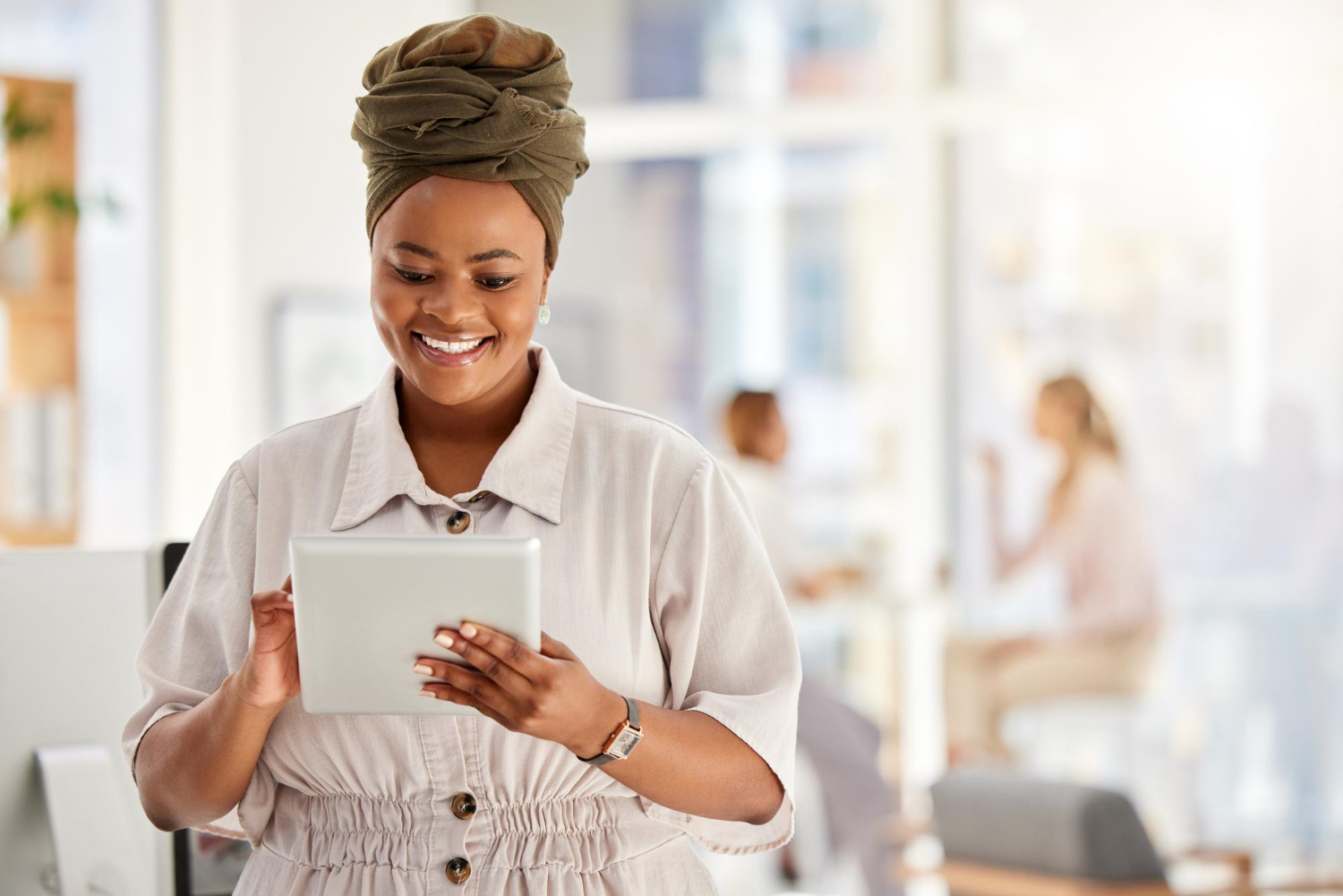 A business owner smiling as she manages her business on a tablet